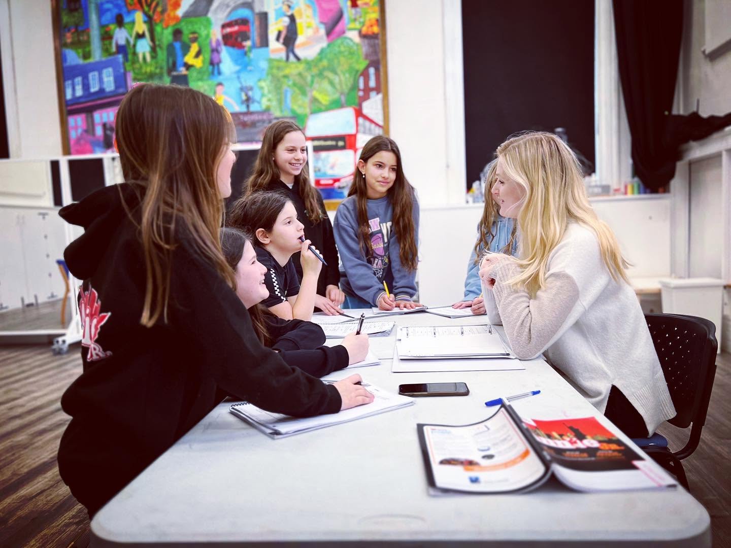 Big Time teacher working with students around a table